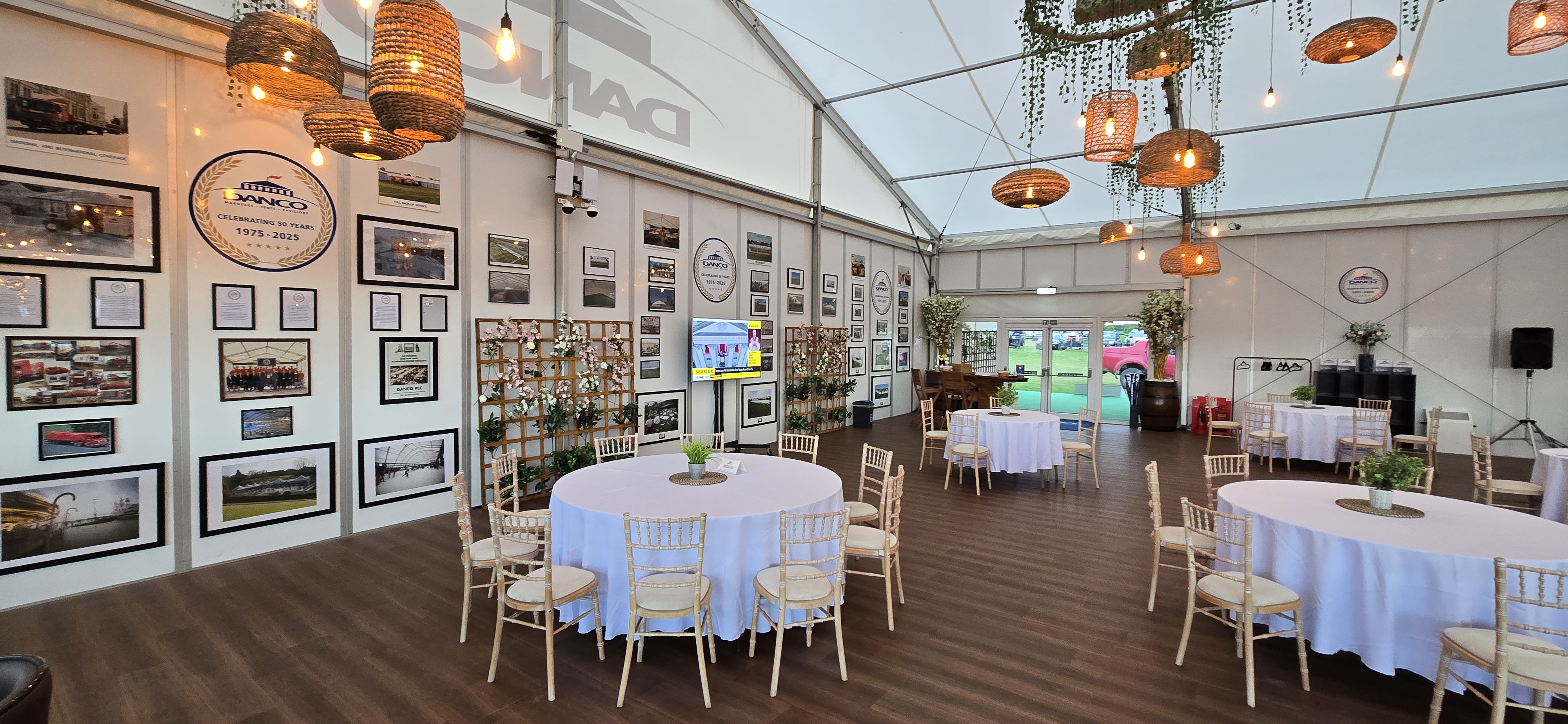 Feature wall showing Danco over 50 years within a large solid sided white hospitality marquee