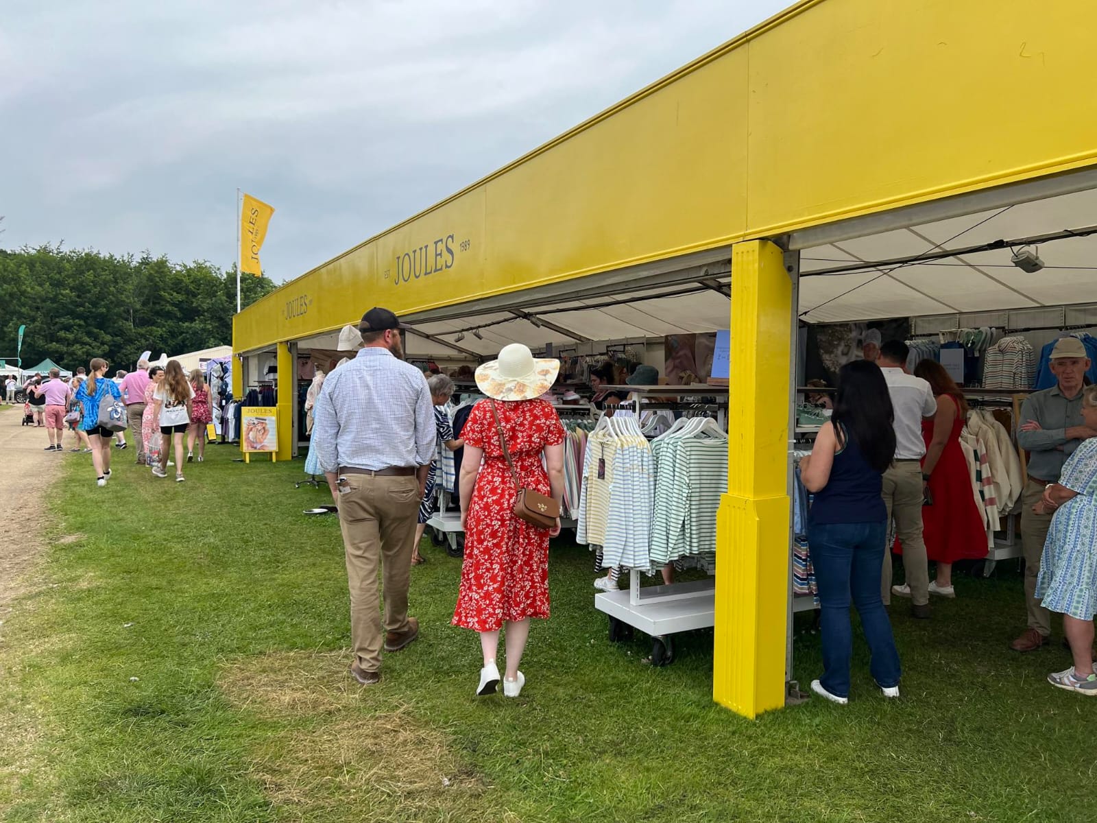 Joules clothing trade stand at the Royal Norfolk Show 2024. Joules branding all in yellow background covers the marquee and customers are seen enjoying the items on offer.