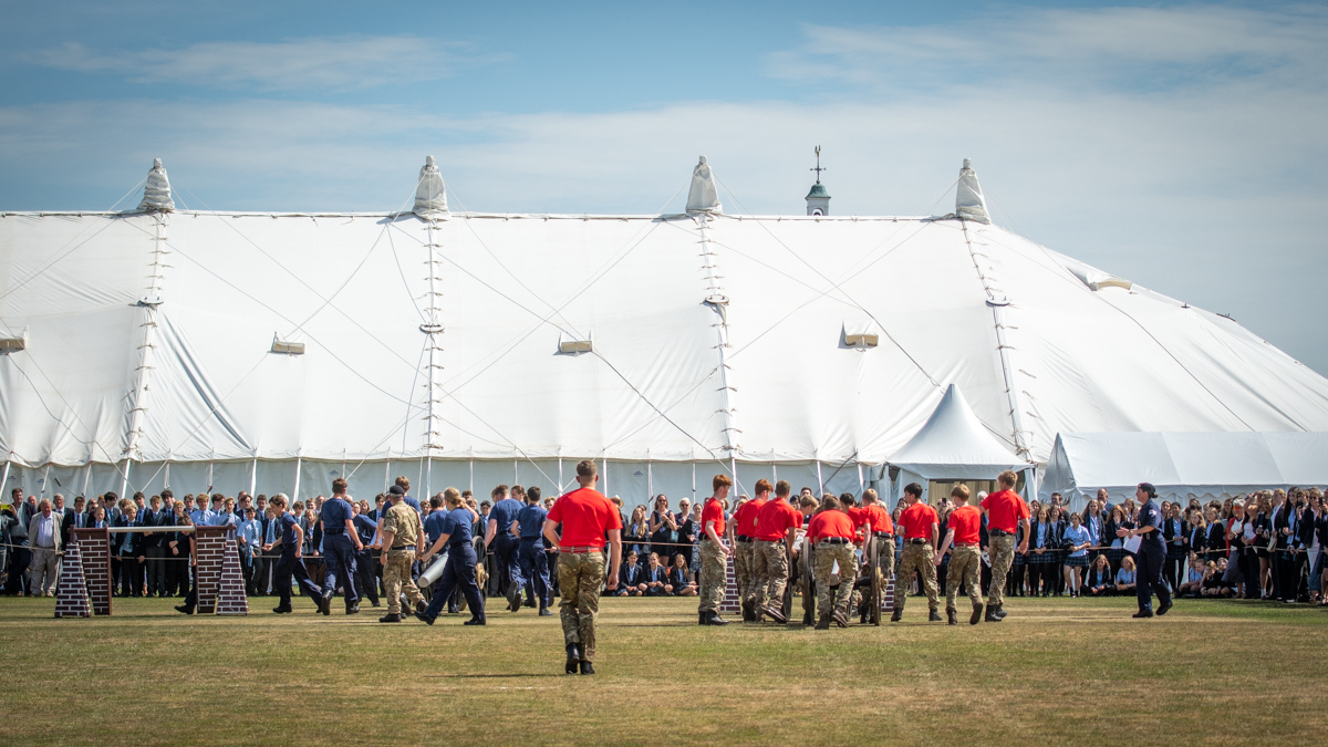 Wellington School Event Day - Army cadets are racing, with spectators and a large white traditional marquee in the background. 