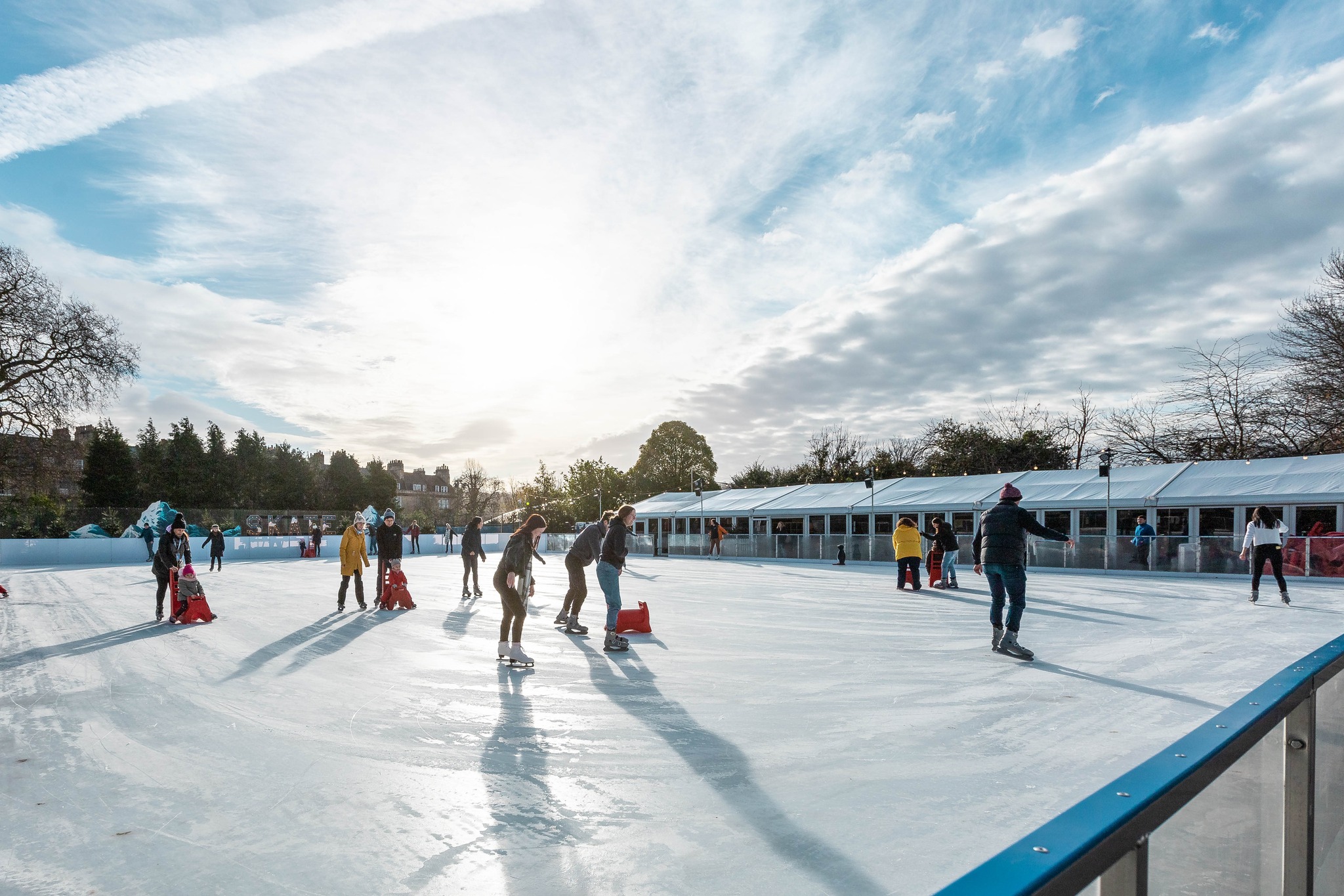 Real ice rink for the winter in the City of Bath. The sun shines on the rink and over the marquee next to the ice rink